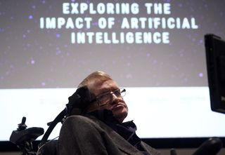 Stephen Hawking in front of a projection with a starry background and the text 