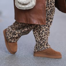 Karin Teigl is seen wearing a calf-length brown leather coat from Prada, wide jeans in leopard print from Bershka, a silver metallic “Wandler“ bag from Miu Miu, and brown suede platform slippers from Copenhagen Studios on November 05, 2024 in Vienna, Austria. (Photo by Jeremy Moeller/Getty Images)