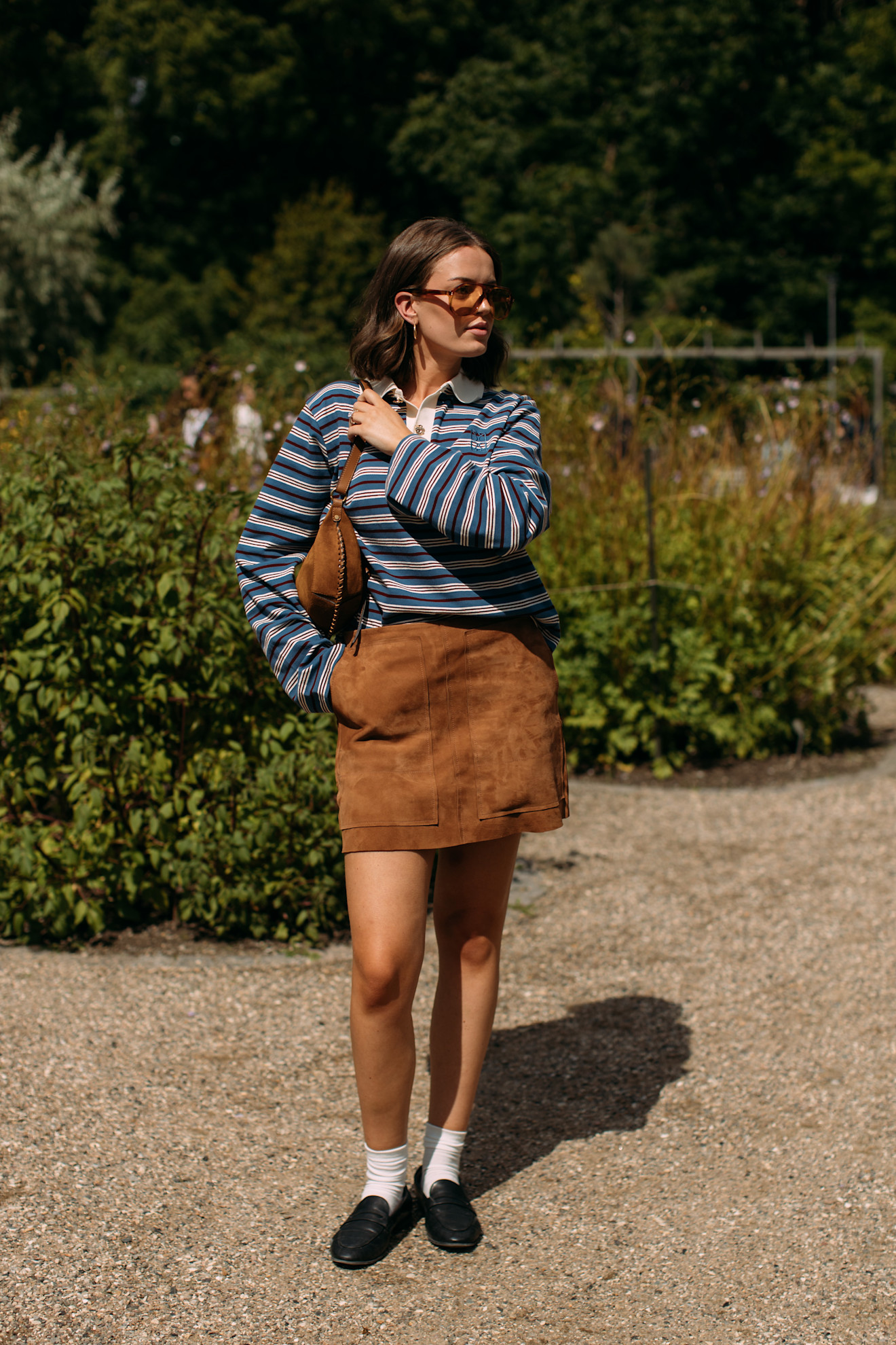 a copenhagen fashion week attendee wearing striped rugby shirt, suede skirt, and loafers