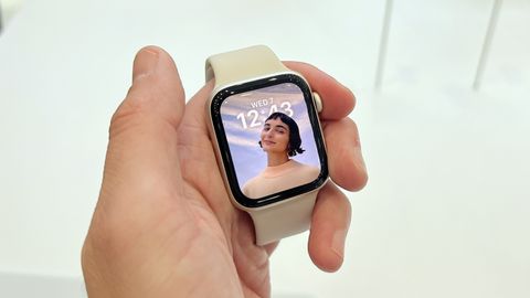 En hand som håller i en vit Apple Watch SE 2.