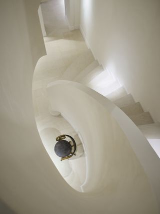 A spiral staircase and chair in New York The Row store