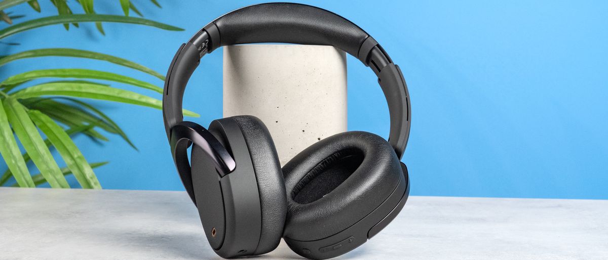 A pair of black Edifier WH950NB over-ear headphones photographed against a blue background