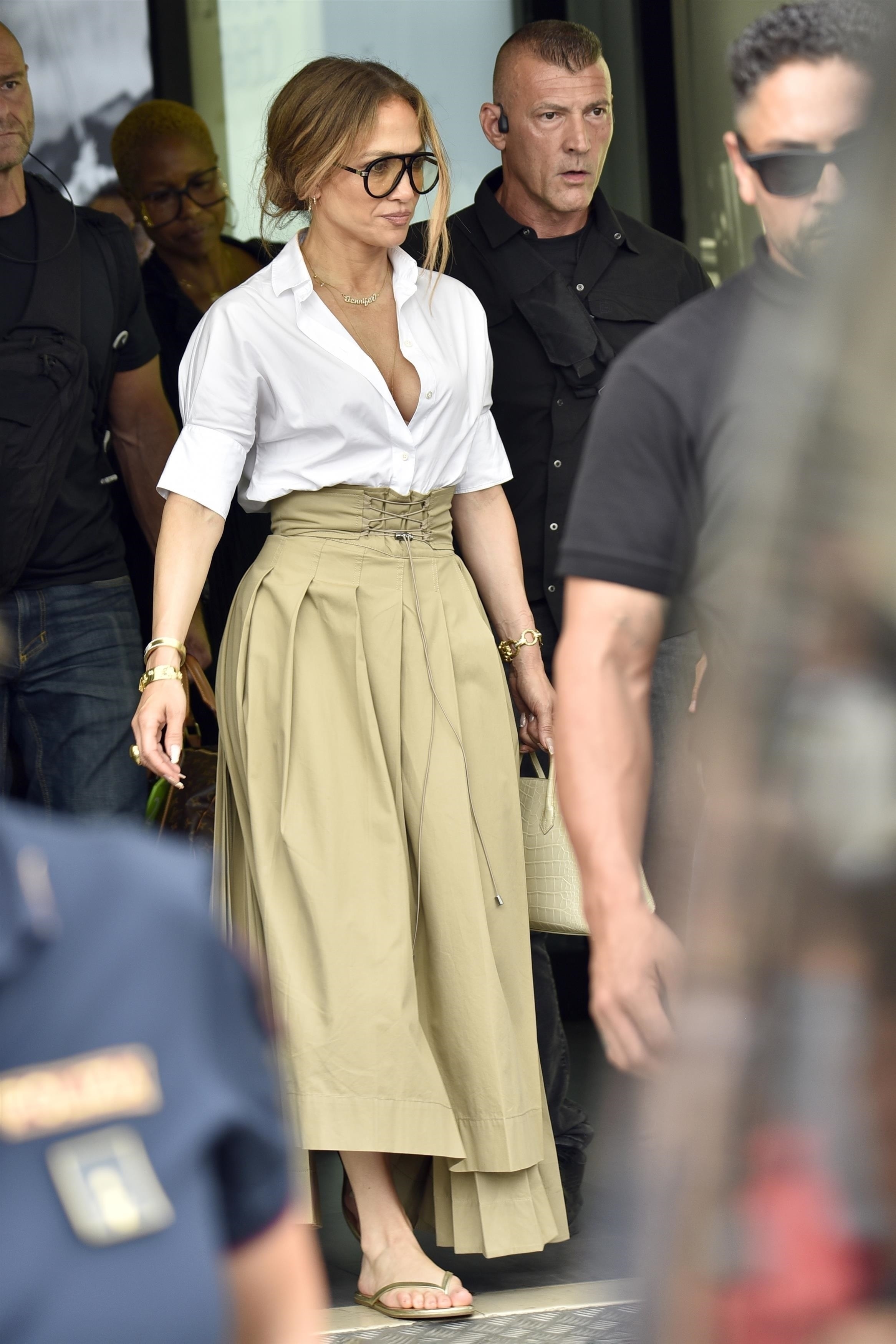 Jennifer Lopez styled an asymmetrical maxi skirt with a white blouse and flip-flops