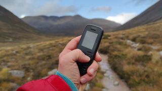 The Nokia 105 (4th gen) against a mountainous backdrop.