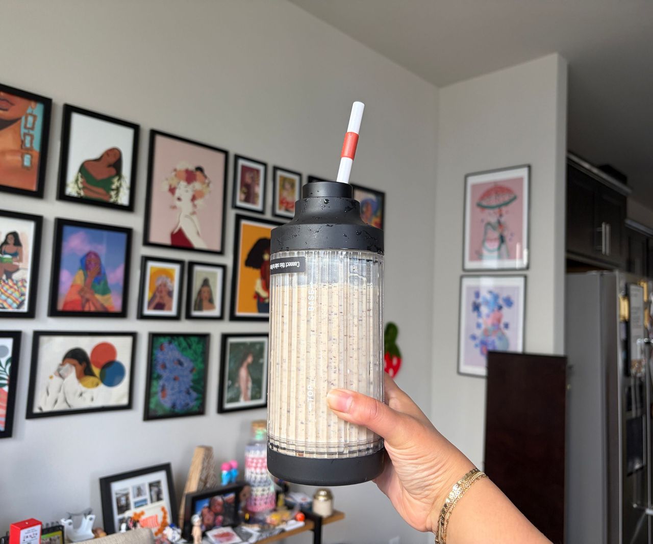 A cream milkshake inside a clear bender pitcher with a black base and lid.