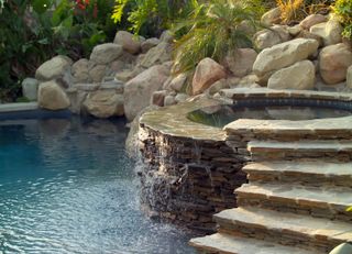 hot tub with waterfall into swimming pool