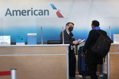 An American Airlines ticket agent checks in a passenger.