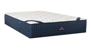 Nectar vs DreamCloud: The DreamCloud Luxury Hybrid Mattress shown with a navy base and a white quilted cover