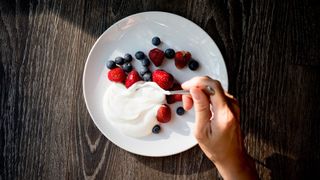 Bowl of yogurt and berries sitting on wooden table