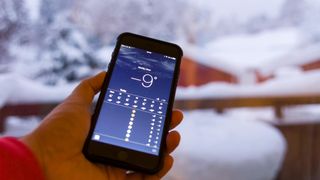 Checking the weather on smartphone with snowy background