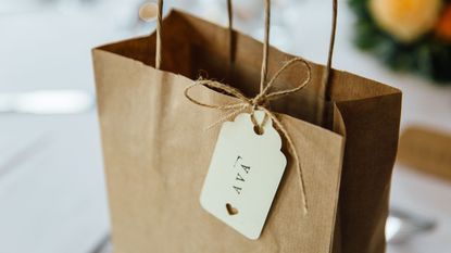 a brown paper gift bag with a printed gift tag