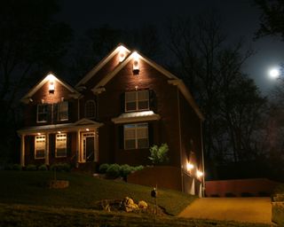 driveway and house lit up at night