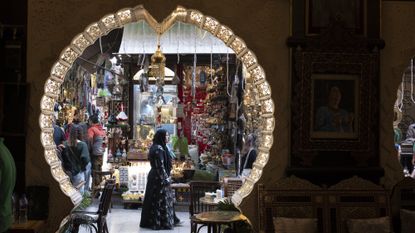 A woman walks in front of an ornate door opening at the Khan El-Khalili market in Cairo, Egypt