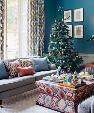 Blue living room with christmas tree and sofa