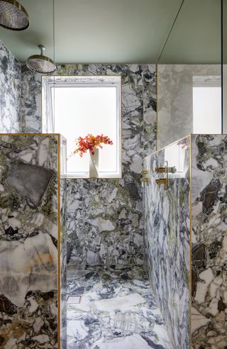 Walk-in shower with marble walls and floor