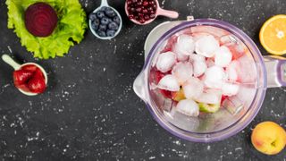 Ice and fruit in a blender looking from above