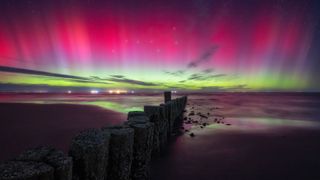 Magenta and green northern lights over Wadden Sea National Parks, Germany.