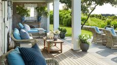 Porch with rattan loungers, daybeds and blue cushions and wood decking
