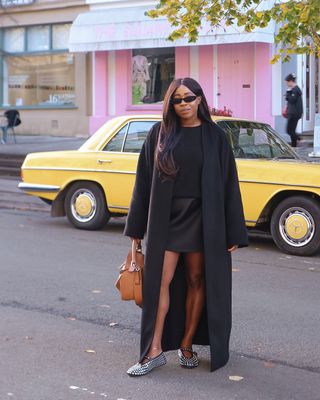 Lois in a black monochrome outfit with jewelled flats