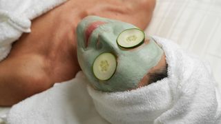 A woman relaxing in a spa with cucumber over her eyes