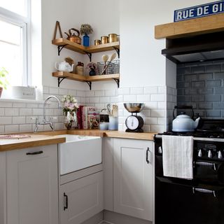 kitchen room with wooden worktop and white metro tiles with white cabinets