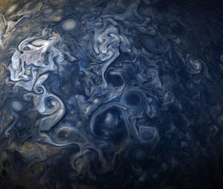 A complex, writhing storm system in Jupiter's northern hemisphere.