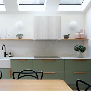 sage green kitchen with white walls and wood handles