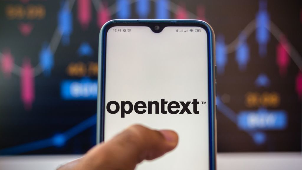 The OpenText logo shown on a phone, with a colourful wall in the background