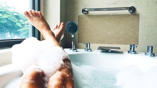 woman in bubble bath with legs resting on side of tub for the ultimate pampering routine