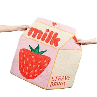 A strawberry milk rug being held by two hands