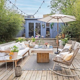 garden decking ara with sofa, chairs and table in front of blue storage unit