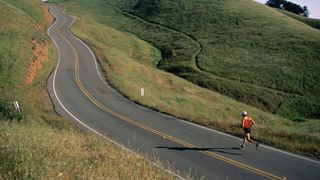 Runner at the foot of a long uphill road
