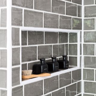 bathroom with rack on grey and white wall