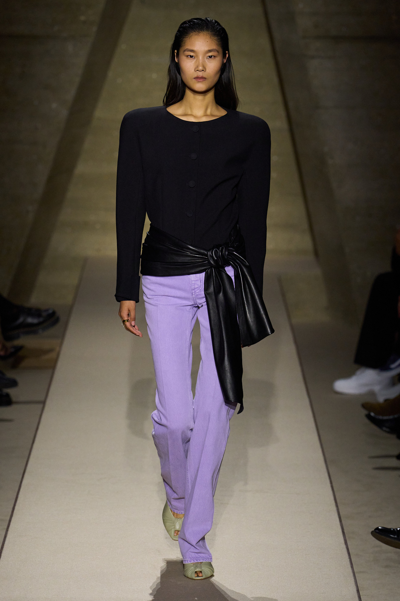 a model at Chloe Spring 26 wearing a black boxy blouse, black leather belt, and purple jeans