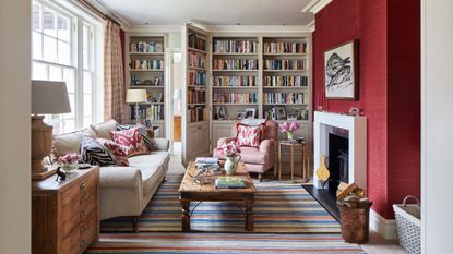 Crimson painted living room with large book case and sofa