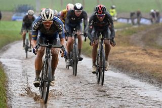 Riders tackling a muddy Paris-Roubaix in October 2021