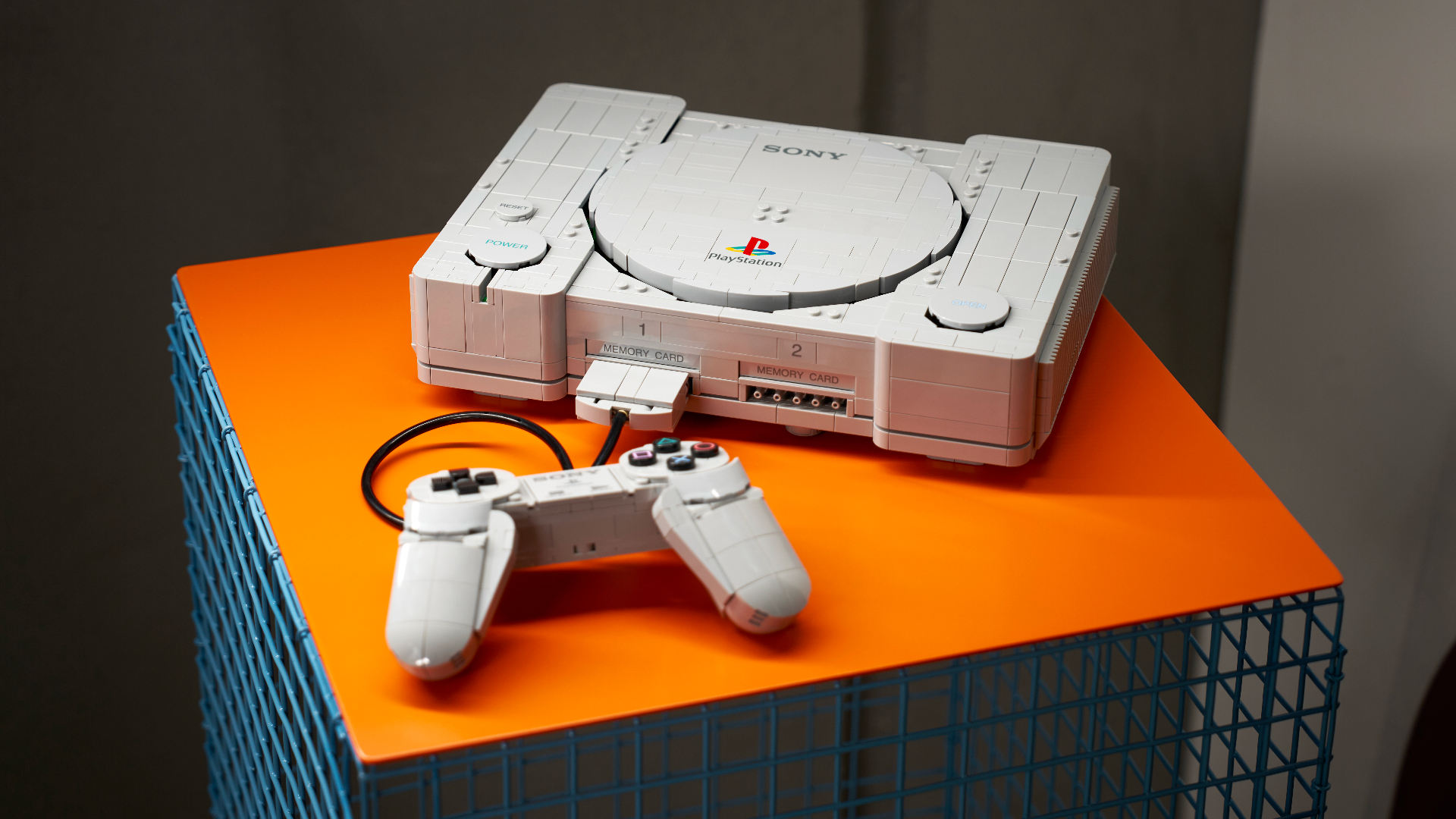 Lego PlayStation and controller on an orange surface