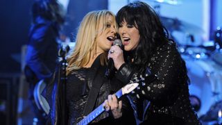 Nancy Wilson (left) performs onstage with her sister, Ann Wilson