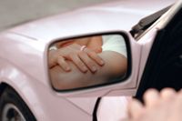Oura Ring lifestyle image - person wearing the Oura Ring in a wing mirror