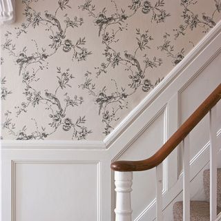 stair case with white railing and wallpaper wall