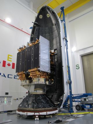 The three Radarsat Constellation Mission satellites are seen together as SpaceX enshrouded them with a payload fairing (background) for a June 12, 2019 launch on a Falcon 9 rocket at Vandenberg Air Force Station, California.