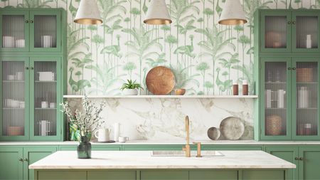 An example of pretty kitchen island pendant lighting ideas. This image shows three gray cone lights with bright golden interior installed above kitchen island with mint green and white leafy wallpaper, green cabinets, white marble surfaces and green base cabinets