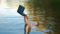 Man drowns in a lake, but tries to save his laptop-it's probably a computer addiction - stock photo