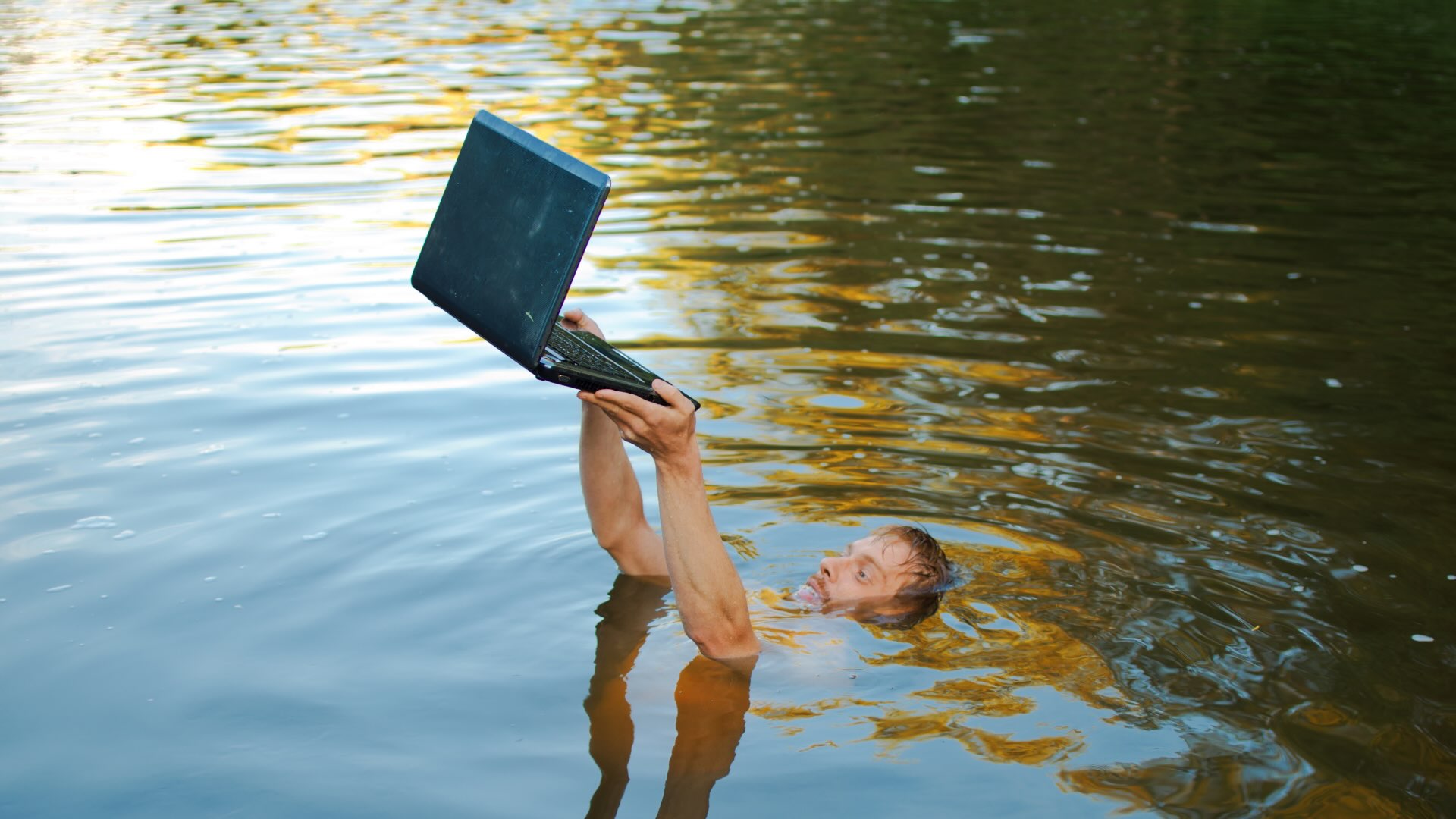 Man drowns in a lake, but tries to save his laptop-it's probably a computer addiction - stock photo