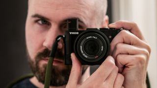 Sony RX1R II camera being held by Dan Mold, as seen in mirror
