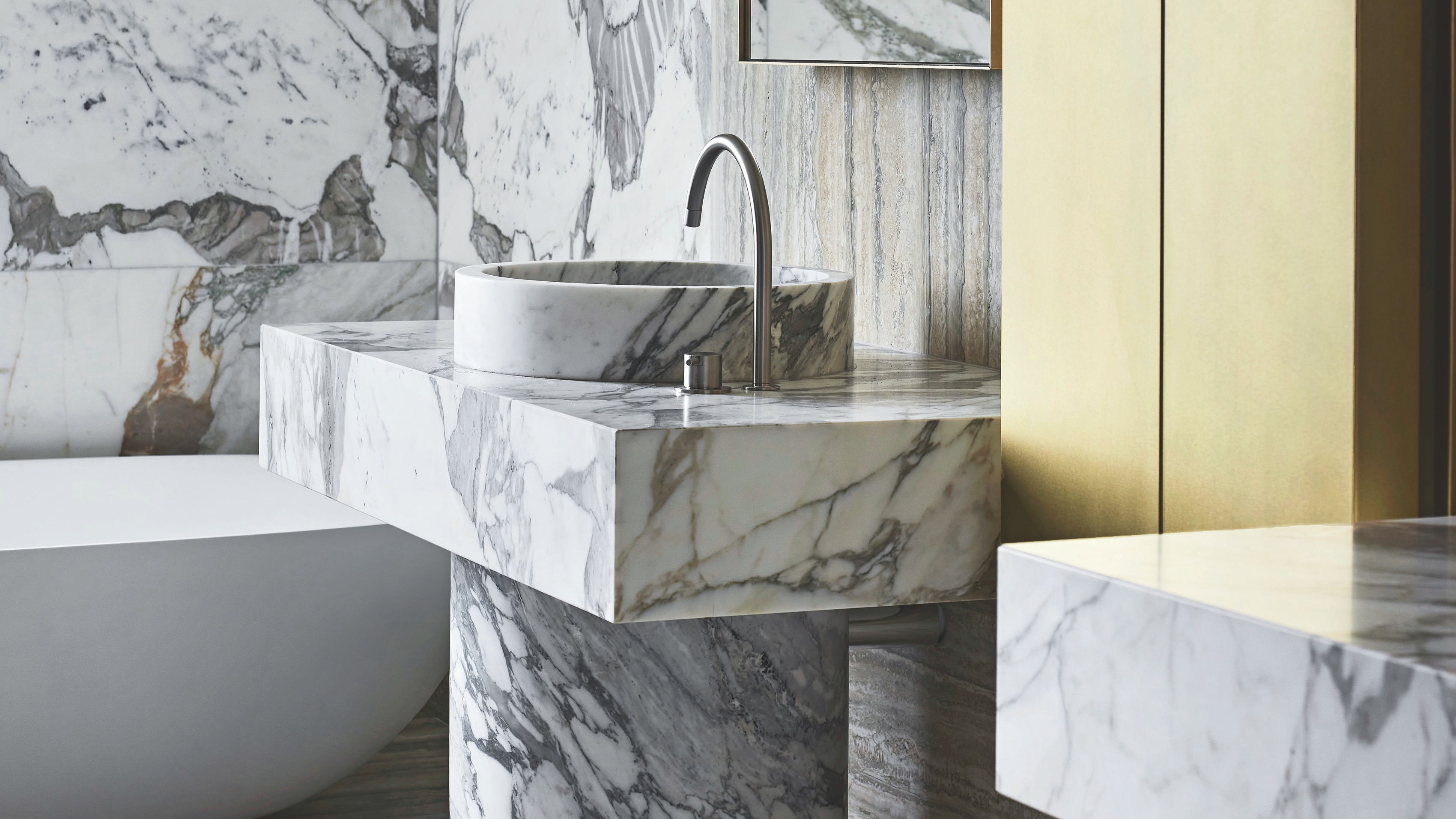 a marble bathroom vanity and basin with a brass cabinet