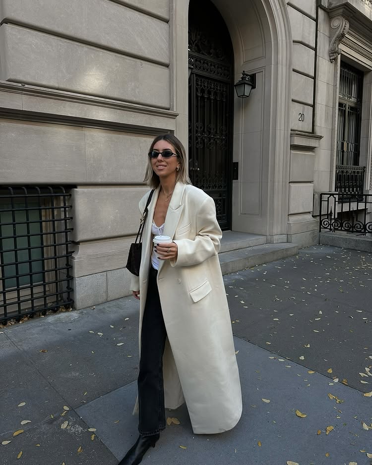 Classic Pieces 2025: @hannahlewisstylist wears a cream maxi coat with black trousers and a white vest top