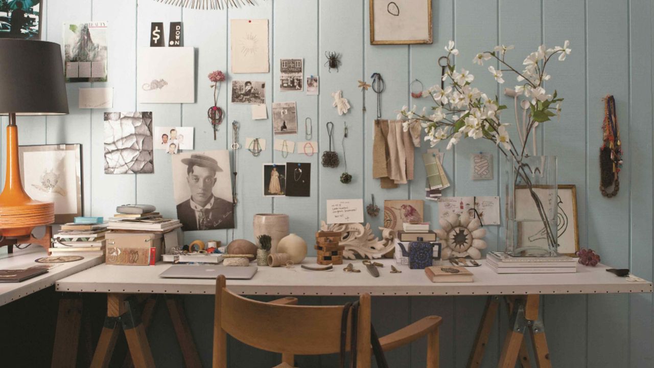 desk with blue panelled wall and lots of decor pieces