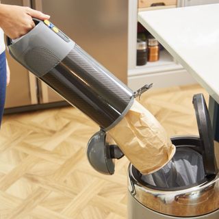 Empty the handheld vacuum cleaner bag into the container