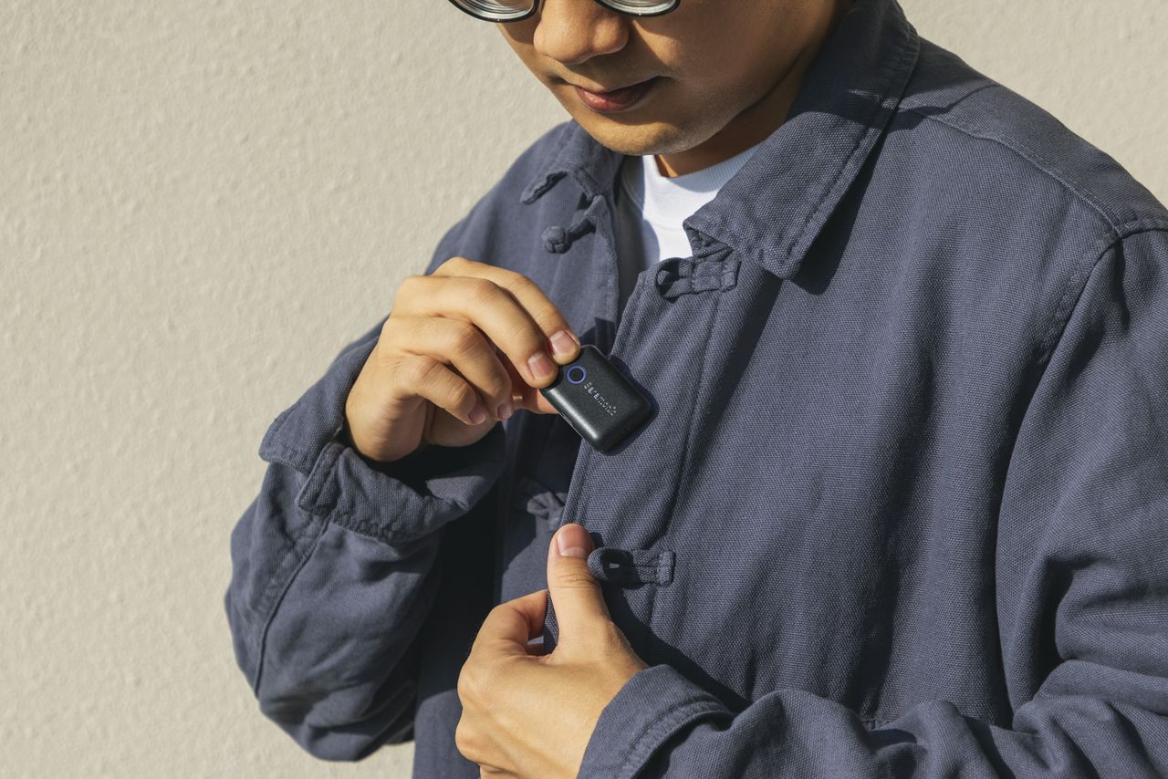 Person attaching the Saramonic Blink500 B2+ transmitter to shirt